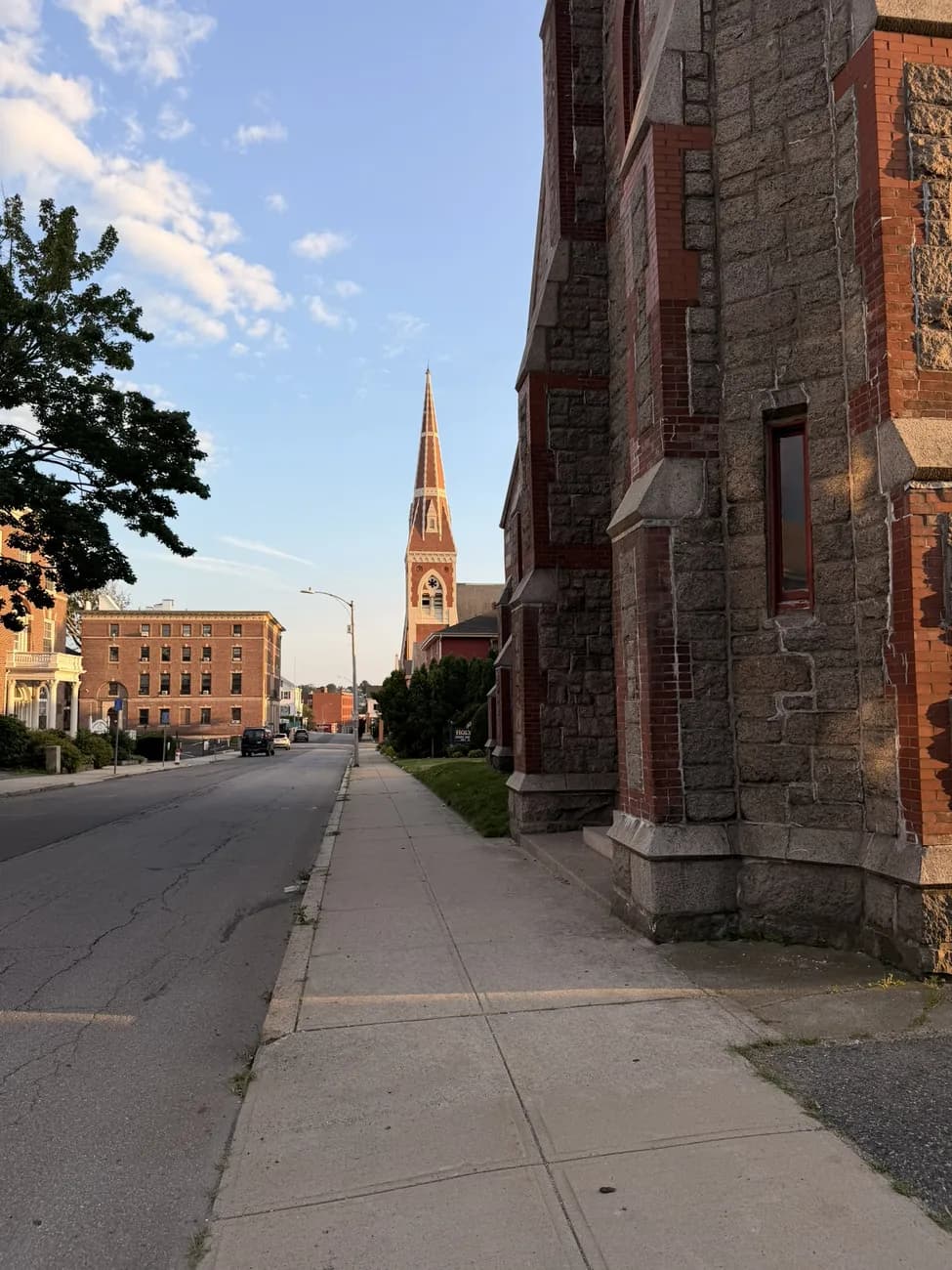 A gothic stone church against a bright summer sky.