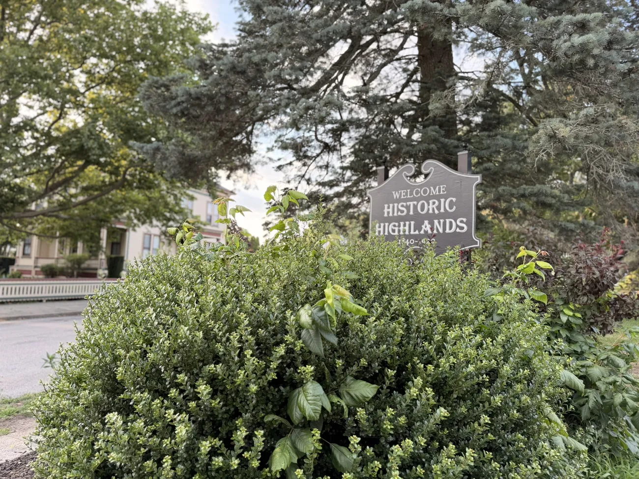 The Historic Highlands marker and a median planted with red begonias.