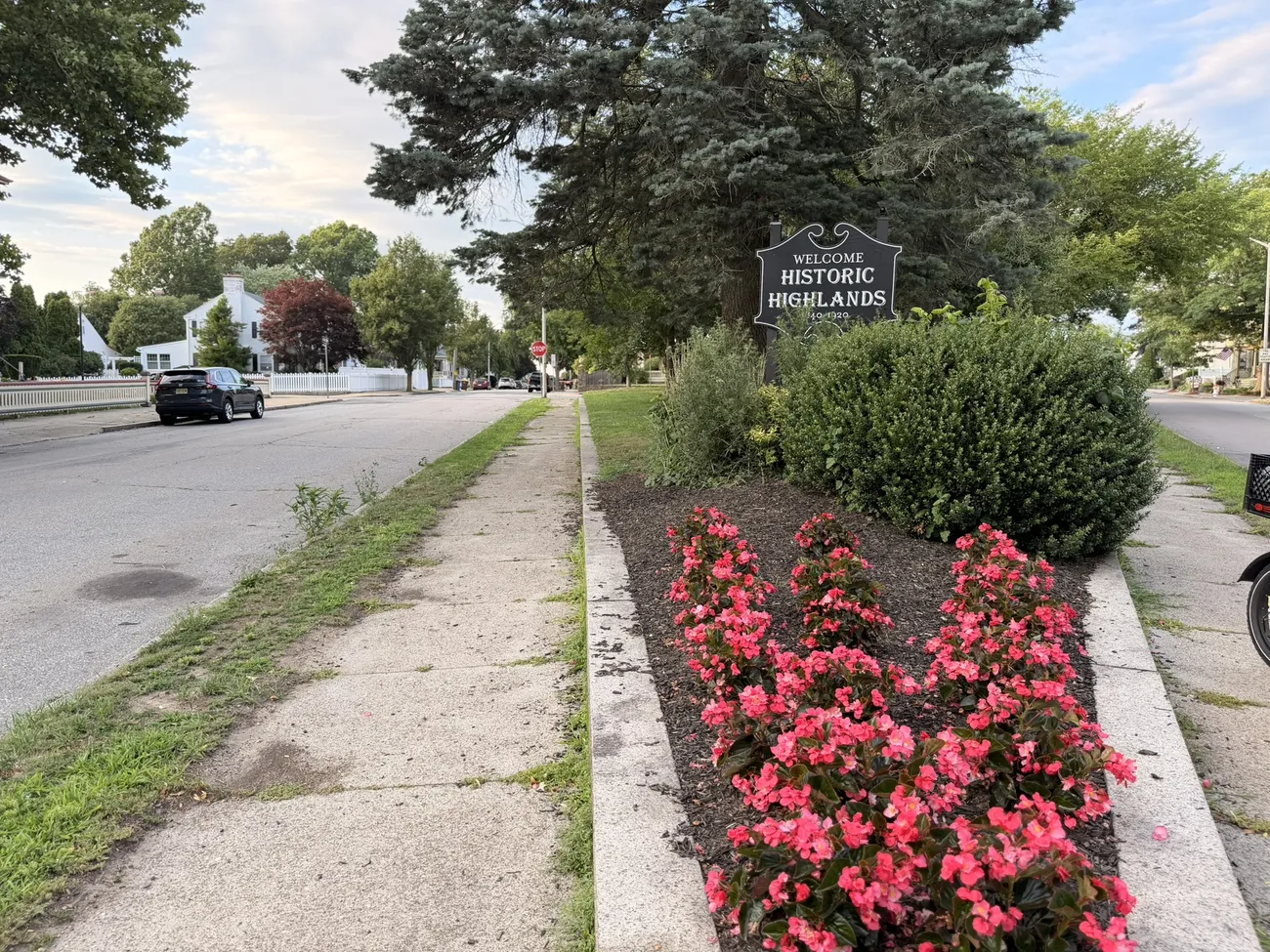 The Historic Highlands marker and a median planted with red begonias.