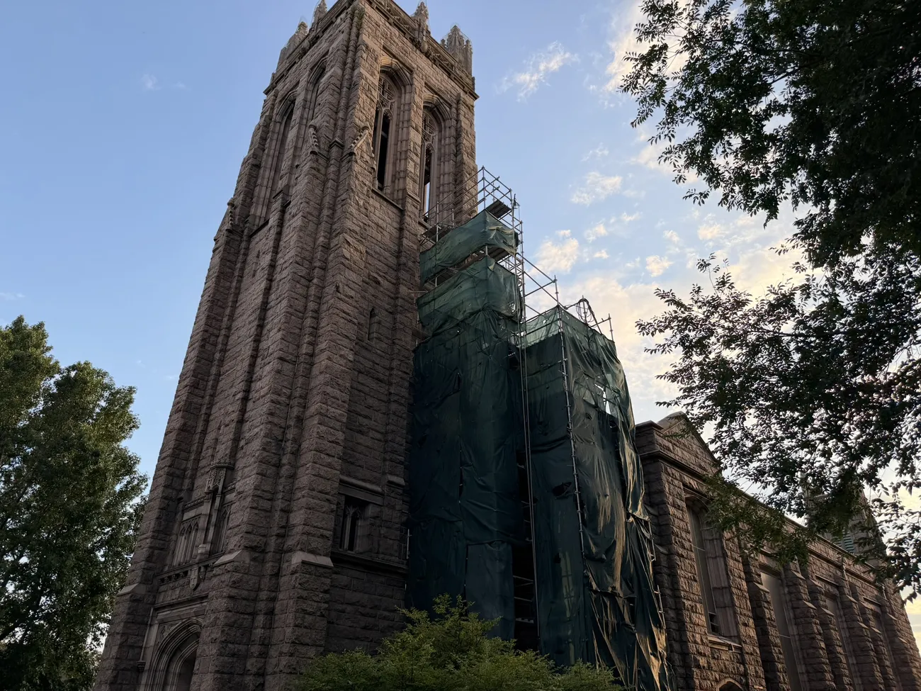 A gothic stone church against a bright summer sky.
