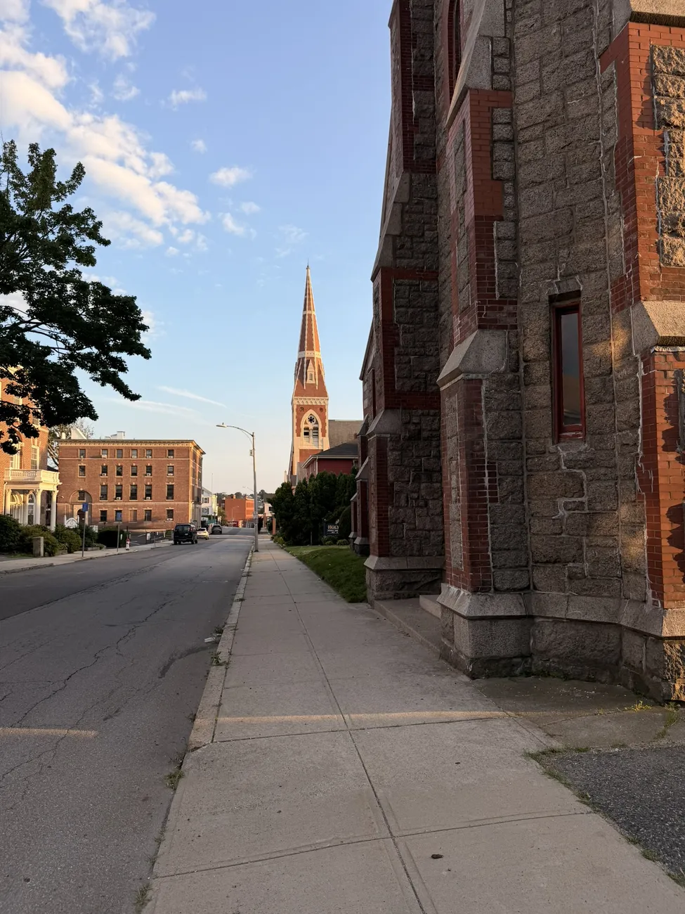 A gothic stone church against a bright summer sky.