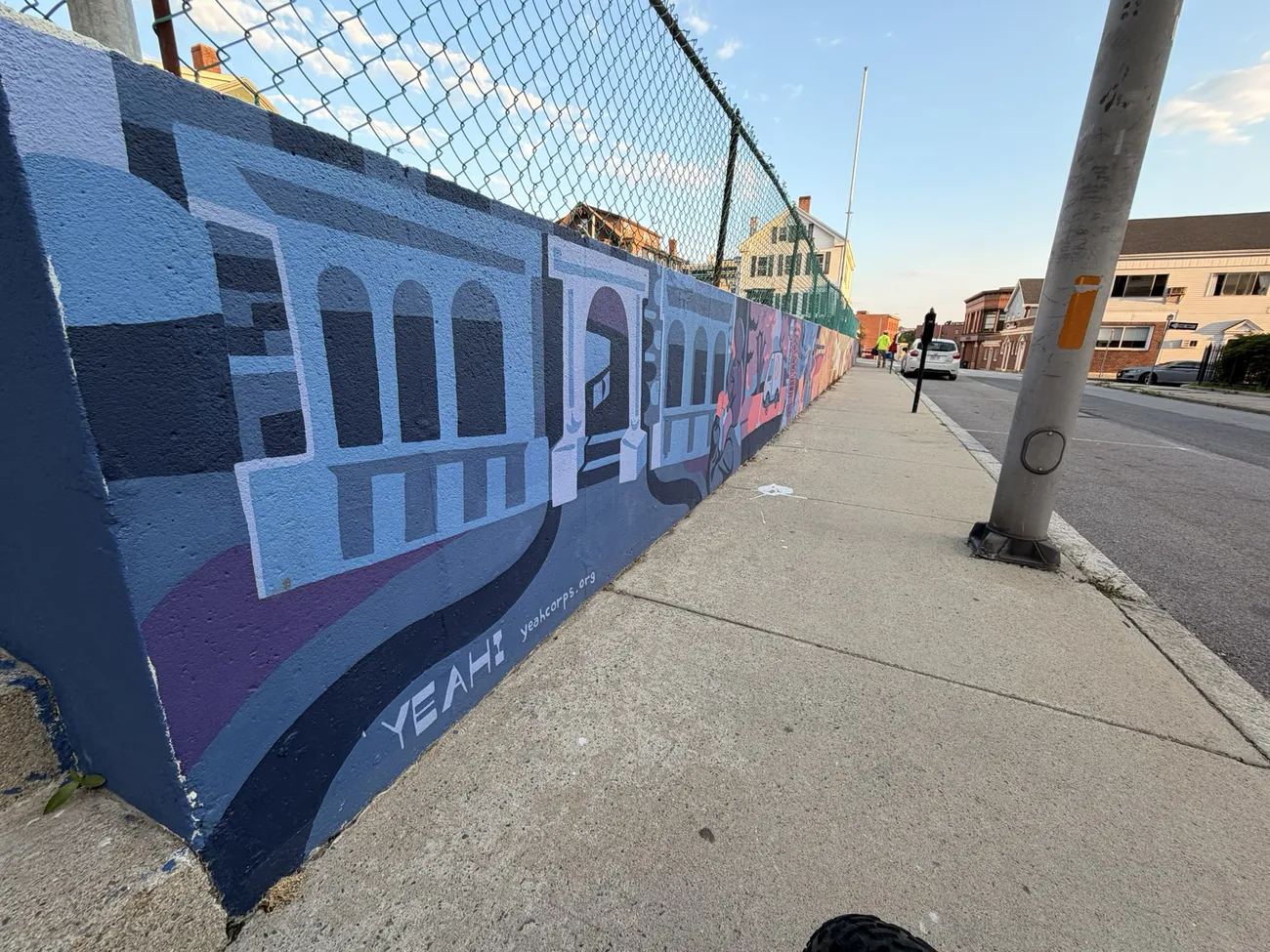 The mural along the Quequechan River Rail Trail — bold blues, pinks and reds.