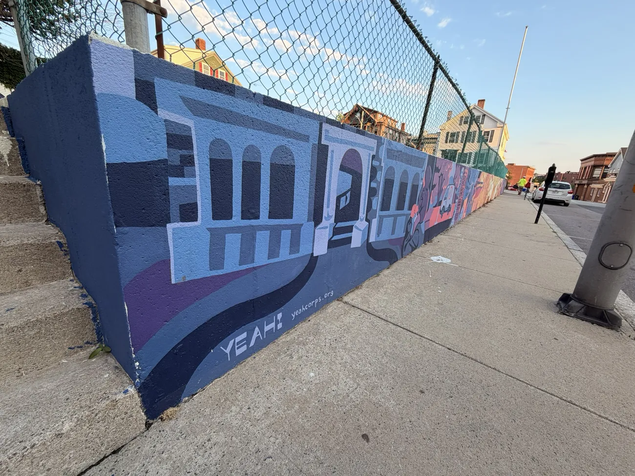 The mural along the Quequechan River Rail Trail — bold blues, pinks and reds.