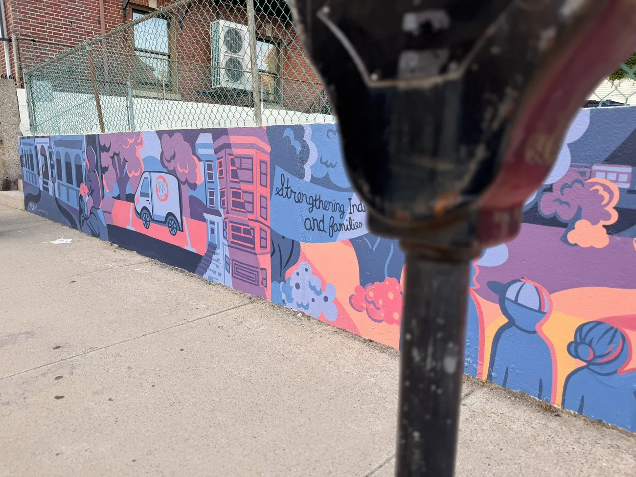 The mural along the Quequechan River Rail Trail — bold blues, pinks and reds.