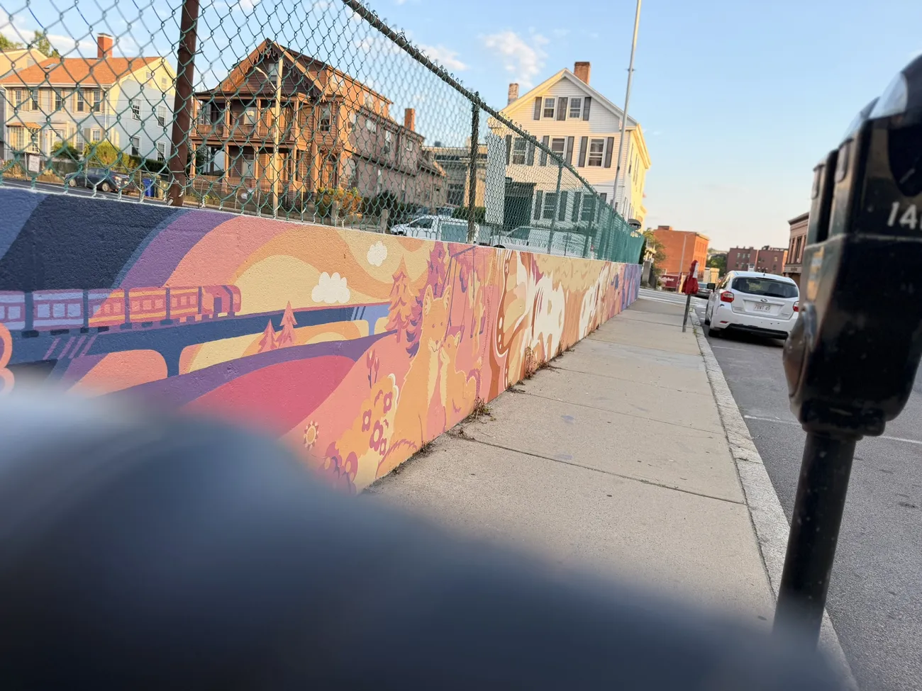 The mural along the Quequechan River Rail Trail — bold blues, pinks and reds.