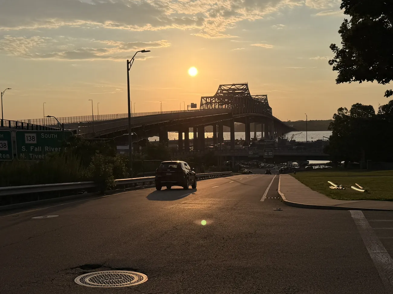 A Fall River street at dusk, the Braga Bridge in the distance.