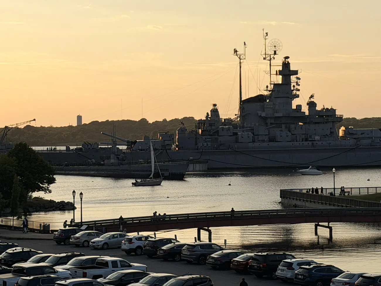 Battleship Cove at golden hour, the USS Massachusetts on still water.